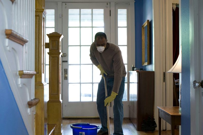 Cleaner mopping a home entryway during a move out cleaning